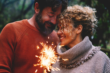 Romantic adult couple enjoy and love together with fire sparkler light in the forest green trees...