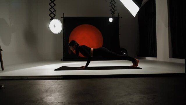 Athletic woman doing yoga in a photo studio. Yoga and meditation concept. 4k