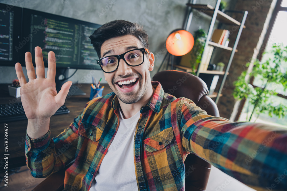 Poster portrait of cheerful friendly it guy sit chair take selfie arm palm waving hi loft workplace busines