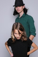 Brother and sister are playing. Sister protects brother. Posing concept. Studio, light background