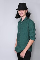 Fashion young guy in slapper with long hair, smiling, studio, standing pose