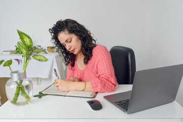front view of businesswoman working in office writing in note book
