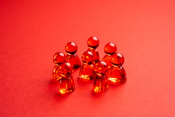 Red glass people figurines. Abstraction. Community or team.