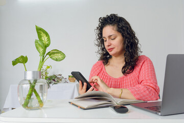 young business woman working in her home office using phone sending messages