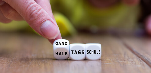 Hand dreht Würfel und ändert den Ausdruck Halbtagsschule in Ganztagschule. - obrazy, fototapety, plakaty