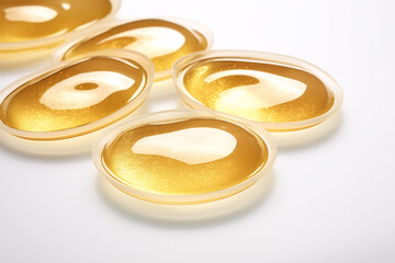 Isolated on a white backdrop, hydrogel eye pads saturated in gold and collagen provide cosmetic moisturizing.