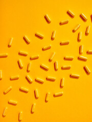 Flat lay pattern various food supplement pills on yellow background