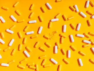 Flat lay pattern various food supplement pills on yellow background