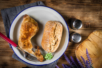 Fried chicken leg with bread roll.