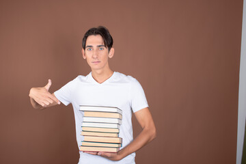 Young man and study. Funny attractive guy posing on a brown background.