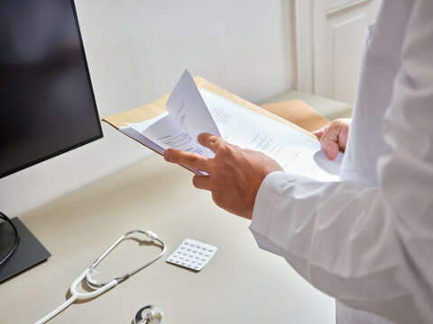 Anonymous medical professional going through the patient's paperwork in a hospital