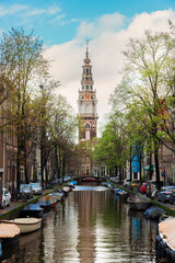 South Church Zuiderkerk bell tower over canal in Amsterdam, Netherlands