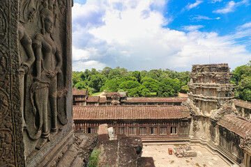 Naklejka premium A view of the main gallery and quadrangle of the Angkor Wat temple complex from the top of the temple with surrounding countryside at Siem Reap, Cambodia, Asia