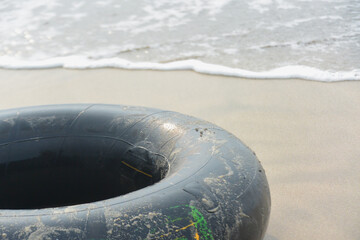 Round rubber buoy on sand and sea water waves