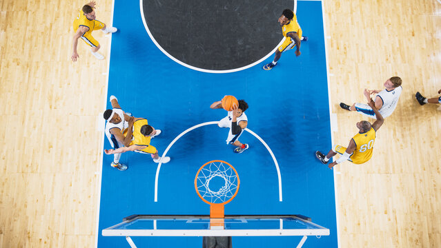 Top Down View of a Talented Basketball Player Jumping To Score Striking Slam Dunk Goal. Shot of Two International Teams Playing Basketball Match at a Professional Arena, Competing In Championship.