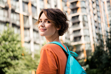 Fototapeta na wymiar Photo of adorable cheerful girl wearing stylish clothes rucksack walking city after going home cityscape outdoors