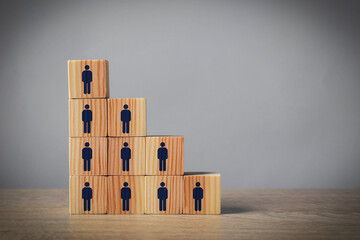 Team and management concept. Wooden cubes with human icons on table against grey background, space...