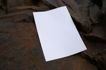 Mockup of a poster on a stone brown background. White blank with space for text or design