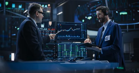Foto op Canvas Two Successful Traders Analyzing Real-Time Financial Data and Reports About the State of the Finance Market. Stock Exchange Professionals Discussing Buy and Sell Options For Different Bonds © Gorodenkoff