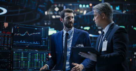 Two Successful Traders Analyzing Real-Time Financial Data and Reports About the State of the...