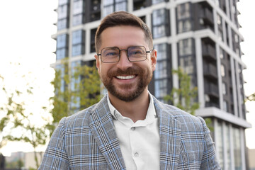 Portrait of handsome bearded man in glasses outdoors