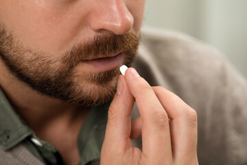 Closeup view of man taking antidepressant pill