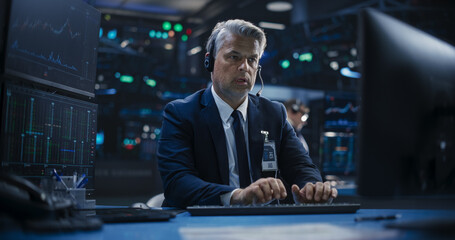 Portrait of a Middle Aged Man Working on the Floor in a Modern Stock Exchange Firm: Specialist Monitoring Listed Companies and Funds, Unit Trusts, Derivatives, Pooled Investment Products and Bonds