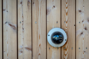 Security camera on the wooden wall of the building