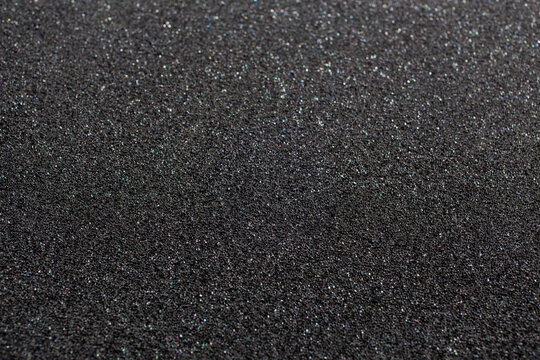 Black foam rubber. Closeup full-frame macro background with selective focus and shallow depth of field.