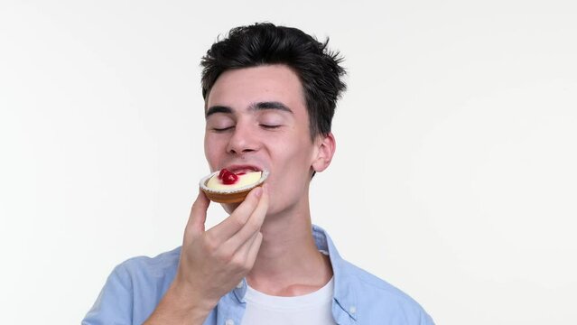 Man revels in the bliss of indulgence as he enjoys a delectable pastry. His eyes close in sheer pleasure, and a contented smile graces lips, reflecting the euphoria of every bite.