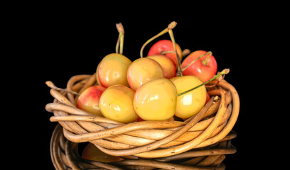 Several yellow cherry berries with vine wreath, macro, isolated on black background.