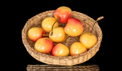 Several yellow cherry berries with straw plate, macro, isolated on black background.