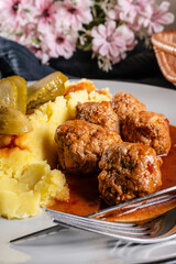 Meatballs pork and mashed potatoes topped with paprika gravy.