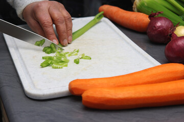 Frau schreidet Staudensellerie in kleine Würfel