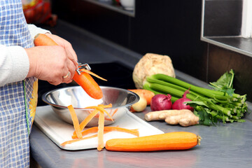 Frau schält eine Karotte