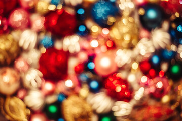 Fototapeta na wymiar Christmas baubles blurred background. Xmas and new year ornaments bokeh texture. Shiny traditional ornaments glitter and glow backdrop wallpaper.