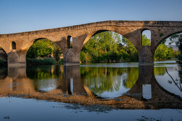 The Early Blue Hour over the Iconic Bridge in Puente la Reina, along the French Way of St James Camino de Santiago Pilgrim Trail - obrazy, fototapety, plakaty