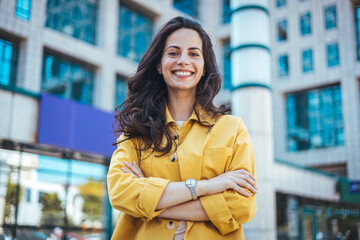 Portrait of young business woman standing outdoors. Close up portrait caucasian young happy woman...