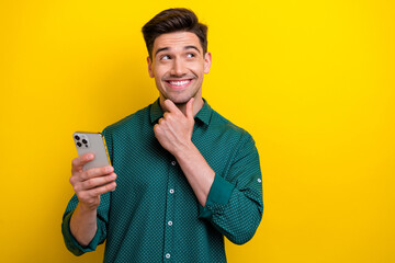 Photo of minded man wear stylish clothes arm hold apple iphone think buy modern device empty space...