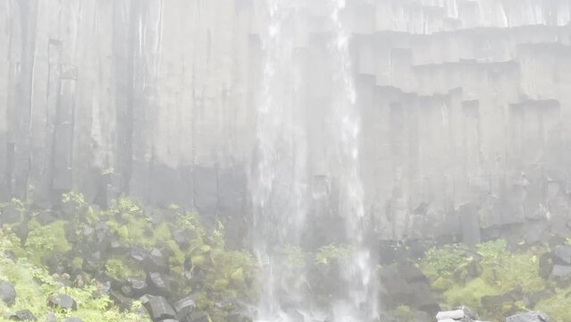 Oudoor high waterfall crashing on basaltic rocks and musk