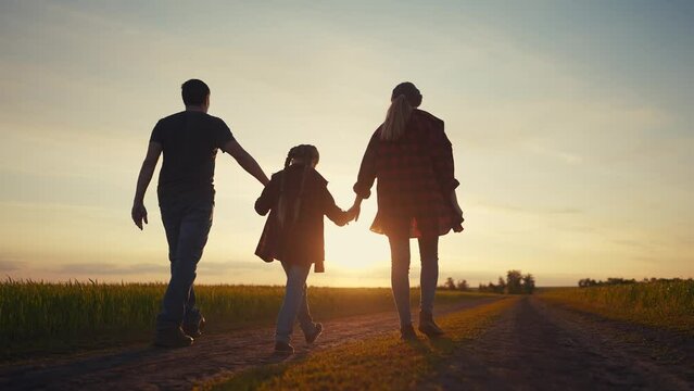happy family in the park at sunset. people group father and daughters walking in nature at sunset in the park. friendly lifestyle family kid dream concept. fathers day concept