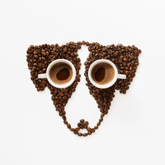 Funny dog made of roasted coffee beans and two cups on white background. Creative concept photo of Jack Russell Terrier dog made of roasted coffee beans