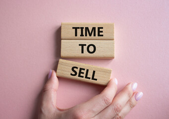Time to Sell symbol. Concept words Time to Sell on wooden blocks. Businessman hand. Beautiful pink background. Business and Time to Sell concept. Copy space.