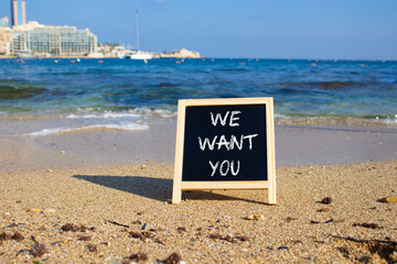 We want you symbol. Concept words We want you on black chalk blackboard blocks. Beautiful sea...
