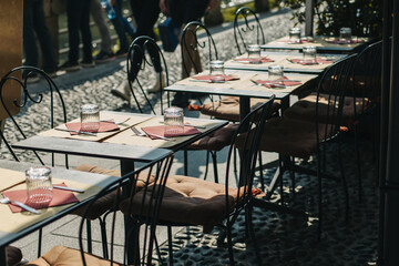 Tables served for lunch in a street cafe on a sunny day.