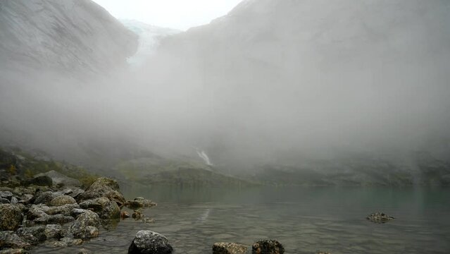 Time lapse in winter, clearing the fog to see the Briksdal Glacier (Briksdalbreen), Norway.