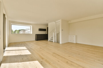 an empty living room with wood flooring and white walls in the room is very light, bright and clean