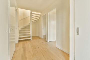 an empty room with wooden floors and white walls, there is a staircase leading up to the second floor in this photo