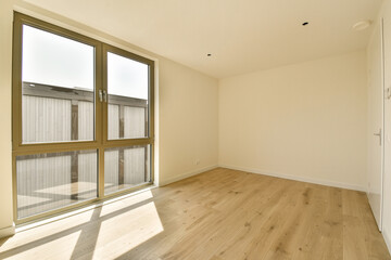 an empty room with wood flooring and sliding glass doors that open to the outside, looking out onto...