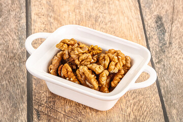 Cracked unshelled walnut in the bowl